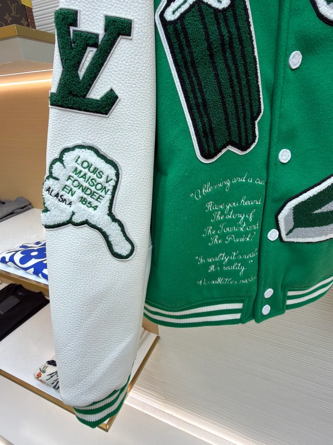 LOUIS VUITTON Loose long-sleeved baseball jersey with monogram pattern ●Original version: Purchased and developed for 29999 ●Item number: 1682254-C10 ●Fabric: cotton fabric ●Technology: embroidery production ●Color: green ●Version: fitted version ●Weight: about 1145 grams ●Size: 46-48-50-52 ●Description: The main body of this Louis Vuitton baseball jacket is made of high-count wool blended fabric. It has been processed by raising and carding processes. The fabric has a full velvety feel and is crisp and stylish. The green base color is made of worsted dyeing process. The color is pure and not easy to fade. The sleeves are spliced ​​with custom pebbled artificial leather, which has been embossed and softened. The texture is natural, flexible to the touch, and is scratch-resistant and wear-resistant. The letters and patterns decorated on the body are made of terry embroidery + appliqué embroidery composite technology. The terry embroidery coils are fluffy and three-dimensional, and the edges of the appliqué embroidery are overlocked to ensure accurate pattern splicing. The handwritten text is made using flat embroidery technology, with fine stitches and clear fonts. The placket is made of custom-made mother-of-pearl buttons, which are hand-polished and polished to have a warm luster; the ribbed neckline and hem are made of spandex blended material, which has good resilience and is not easy to loosen. The overall design uses three-dimensional tailoring and hand-sewing techniques to integrate a variety of materials and embroidery techniques to fully demonstrate the essence of haute couture garments. The overall wiring is straight and delicate, the fabric is comfortable and soft, and the color is consistent without color difference. It can be matched with the same style to create a fashionable look and control various occasions. Customized accessories, complete with three standards, same style for men and women!